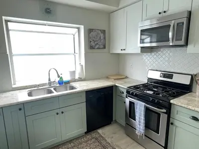a kitchen with a stove and a sink and a microwave at Luxe 2-BR with King suite, rooftop, steps from beach in Los Angeles