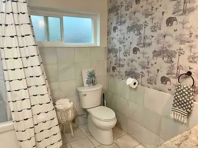 a bathroom with a toilet and a shower curtain at King Oasis - steps to beach with garden patio! in Los Angeles
