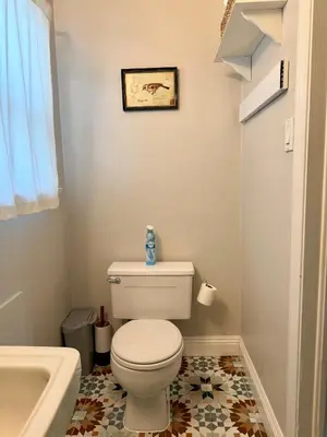 a bathroom with a white toilet and a sink at Historic, Family-Friendly Home in Downtown in Bakersfield