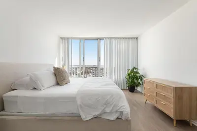 a white bedroom with a large bed and a window at The violet-Santa Monica highrise beach front&view in Los Angeles