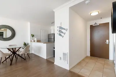 a living room and kitchen with a table and chairs at The violet-Santa Monica highrise beach front&view in Los Angeles