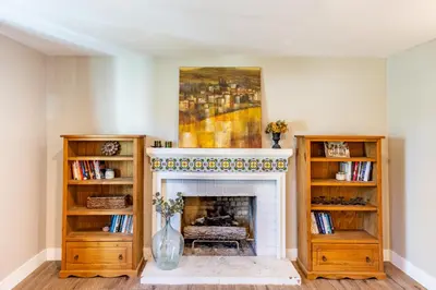 a living room with a fireplace and a painting on the wall at Spacious 4BR Retreat near Disneyland & Beaches in Placentia