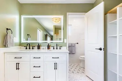 a white bathroom with a sink and a mirror at Spacious 4BR Retreat near Disneyland & Beaches in Placentia