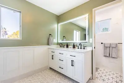 a bathroom with a sink and a tub and a mirror at Spacious 4BR Retreat near Disneyland & Beaches in Placentia