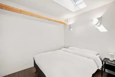 a small white bedroom with a bed and a window at Scenic Retreat with Deck & Stunning Views in LA in Glendale