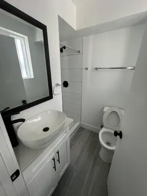 a white bathroom with a sink and a toilet at Cultura Homes On Crawford in Los Angeles
