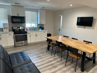a large kitchen with a wooden table and chairs at Cultura Homes On Crawford in Los Angeles