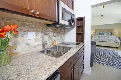 a kitchen with a sink and a bedroom with a bed at In The Village With Private Entrance in Claremont