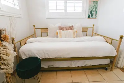a bedroom with a bed with white sheets and pillows at LA Karaoke Fire Pit Ping-Pong Cowboy Pool in Glendale