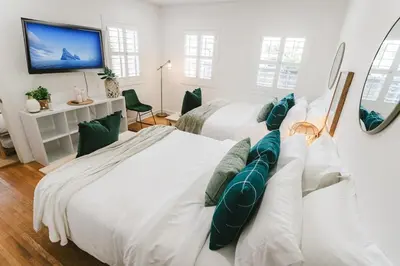 a bedroom with two beds and a tv on a wall at LA Karaoke Fire Pit Ping-Pong Cowboy Pool in Glendale