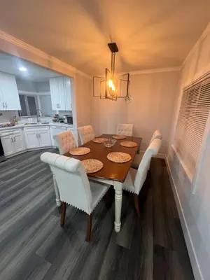 a dining room with a wooden table and white chairs at Vacation-Poppy Fields, Antelope Valley & Aerospace in Lancaster