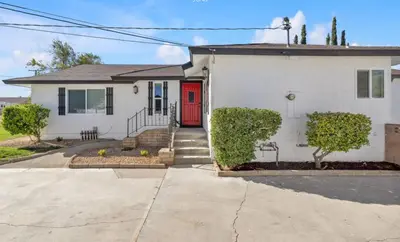 a white house with a red door at Vacation-Poppy Fields, Antelope Valley & Aerospace in Lancaster