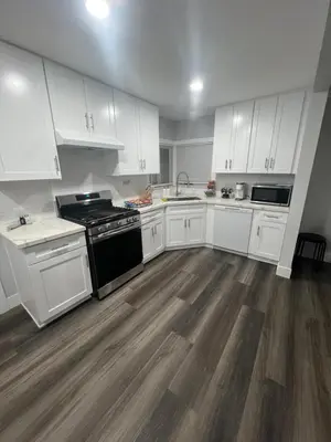 a kitchen with white cabinets and a black stove at Vacation-Poppy Fields, Antelope Valley & Aerospace in Lancaster