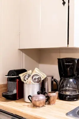 a kitchen counter top with cups and appliances on it at Contemporary Classic on a Private Mountain Lake in Lake Arrowhead