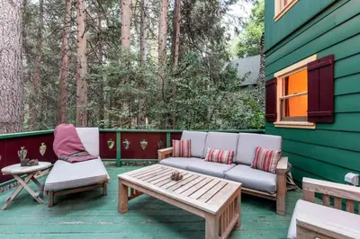a patio with a couch and a coffee table at Contemporary Classic on a Private Mountain Lake in Lake Arrowhead
