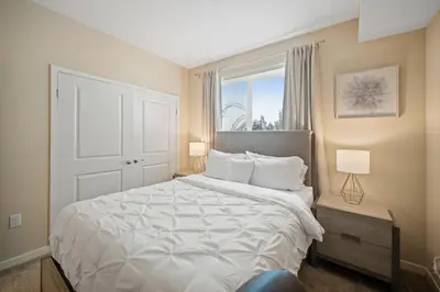 a bedroom with a large white bed with a window at Chic 1BR Retreat with Pool, Gym & Jacuzzi in Mid Wilshire & Miracle Mile in Los Angeles
