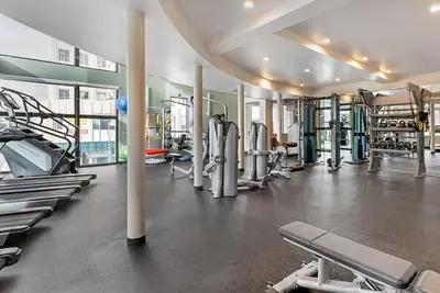 a gym with a lot of treadmills and machines at Chic 1BR Retreat with Pool, Gym & Jacuzzi in Mid Wilshire & Miracle Mile in Los Angeles
