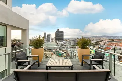 a balcony with a table and chairs on a building at Chic 1BR Retreat with Pool, Gym & Jacuzzi in Mid Wilshire & Miracle Mile in Los Angeles