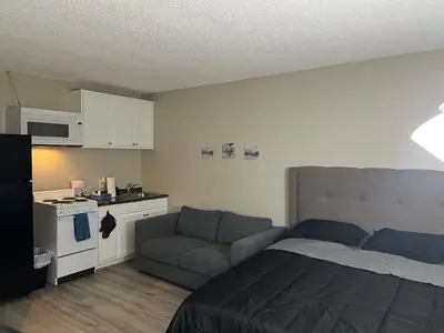 a bedroom with a bed and a couch and a kitchen at NoHo Cozy Cove in Burbank