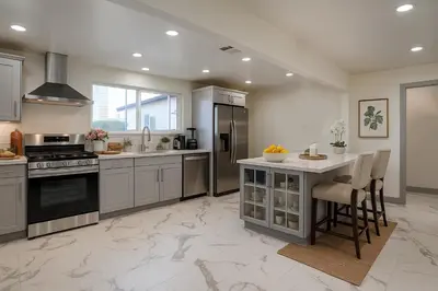 a large kitchen with stainless steel appliances and a table at The Pacific Nest - 10min from LAX in Hawthorne