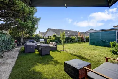 a backyard with a lawn with chairs and tables at The Pacific Nest - 10min from LAX in Hawthorne