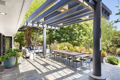 a patio with a table and chairs under a pergola at Malibu Park by Stay Awhile Villas in Malibu