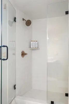 a bathroom with a shower with a glass door at The South Bay Retreat in Redondo Beach