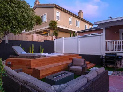 a backyard with a patio with a bench and a grill at The South Bay Retreat in Redondo Beach