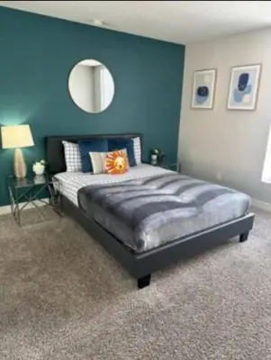 a bedroom with a large bed with a blue wall at 2-Bedroom Hollywood Apartment in Los Angeles