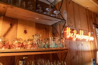a bunch of glasses on a shelf in a room at BunkHouse 1960's Camp Vibe with Timeless Wet Bar in Springville