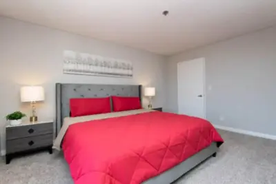 a bedroom with a large red bed with red pillows at 2BR Hollywood Apt Deluxe in Los Angeles