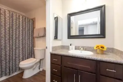 a bathroom with a toilet and a sink and a mirror at 2BR Hollywood Apt Deluxe in Los Angeles