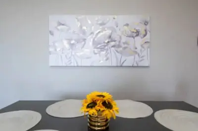 a vase with flowers on a table with two plates at 2BR Hollywood Apt Deluxe in Los Angeles