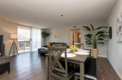 a living room with a table and a dining room at 2BR Hollywood Apt Deluxe in Los Angeles