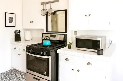 a kitchen with a stove and a microwave at Enchanting Gated Hollywood Hills Oasis with Tranquil Treet-Top Views, Outdoor Living Room and Patios, Magical Zen Garden, Plus Bonus Romantic Guest House and Free Garage in LA's Most Desirable Central Serene Area, Sleeps 8-10 in Los Angeles