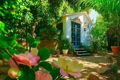 a house with a blue door and some flowers at Enchanting Gated Hollywood Hills Oasis with Tranquil Treet-Top Views, Outdoor Living Room and Patios, Magical Zen Garden, Plus Bonus Romantic Guest House and Free Garage in LA's Most Desirable Central Serene Area, Sleeps 8-10 in Los Angeles