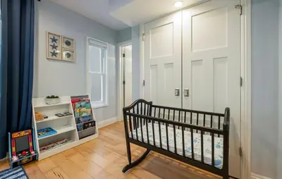 a baby room with a crib and a door at Sea La Vie Beachhouse on the sand in Long Beach
