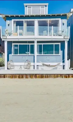 a house on the beach with a hammock in front of it at Sea La Vie Beachhouse on the sand in Long Beach