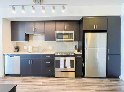 a kitchen with black cabinets and stainless steel appliances at Studio Downtown Walk to Convention Center in Los Angeles