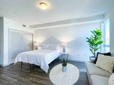 a bedroom with a bed and a couch and a table at Studio Downtown Walk to Convention Center in Los Angeles