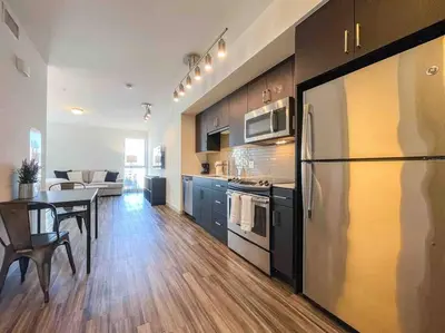 a kitchen with a refrigerator and a table in it at Studio Downtown Walk to Convention Center in Los Angeles