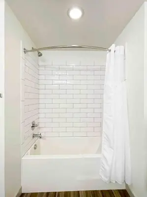 a white bathroom with a bath tub with a shower curtain at Studio Downtown Walk to Convention Center in Los Angeles