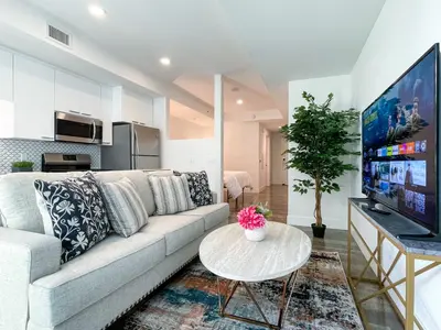 a living room with a couch and a tv at Suite Downtown Pool and Gym Access in Los Angeles