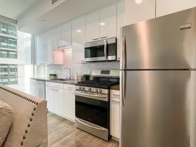 a kitchen with a stainless steel refrigerator and a microwave at Suite Downtown Pool and Gym Access in Los Angeles