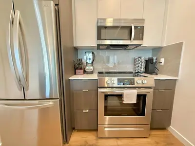 a kitchen with a stainless steel refrigerator and a microwave at 3 Bedroom 2 Bath Westwood Condo in Los Angeles