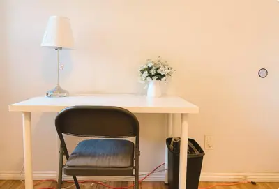 a table with a chair and a vase of flowers on it at Happy Room Near Citrus College in Glendora
