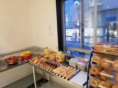 a bakery counter with a bunch of donuts and other pastries at Samesun Hollywood Hotel & Hostel in Los Angeles