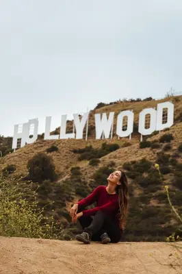 a woman sitting in front of the hollywood sign at Samesun Hollywood Hotel & Hostel in Los Angeles