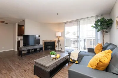 a living room with a blue couch and a tv at Chic Hollywood Retreat 2Bed Rooftop Pool with Iconic Views in Los Angeles