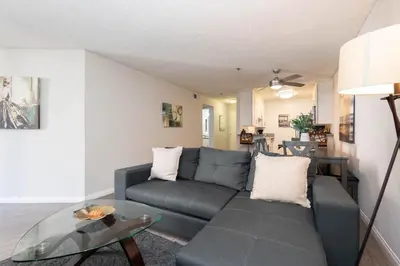 a living room with a couch and a glass table at Hollywood Luxe 2BR Apartment with Rooftop Pool and Breathtaking Views in Los Angeles
